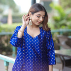 Elegant woman posing outdoors in a blue handwoven silk suit, ideal for wedding guest or festive wear.