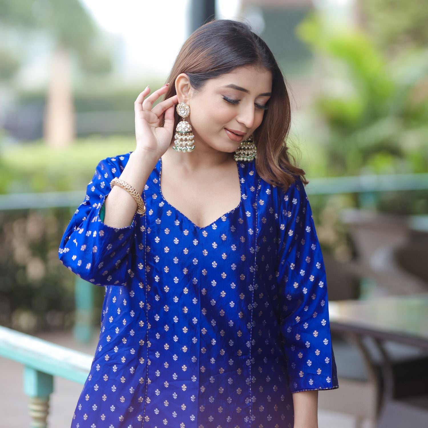 Elegant woman posing outdoors in a blue handwoven silk suit, ideal for wedding guest or festive wear.