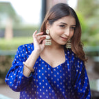 Elegant woman posing outdoors in a blue handwoven silk suit, ideal for wedding guest or festive wear.