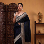 A model posing in a royal blue handwoven Mashru silk saree featuring a detailed silver zari border and an elegant draped palla.