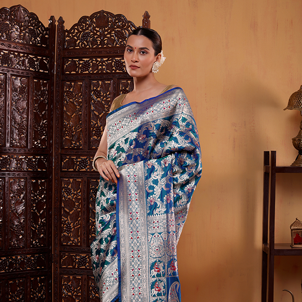 Close-up of the elegant Meenakari border featuring fine gold Zari and Resham embroidery on a premium blue base.