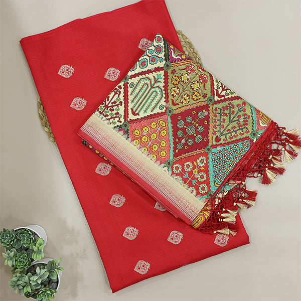 Close-up view of the luminous carrot red dress material, showcasing the authentic textures and fine gold zari motifs of the traditional handwoven Banarasi Khadua technique.