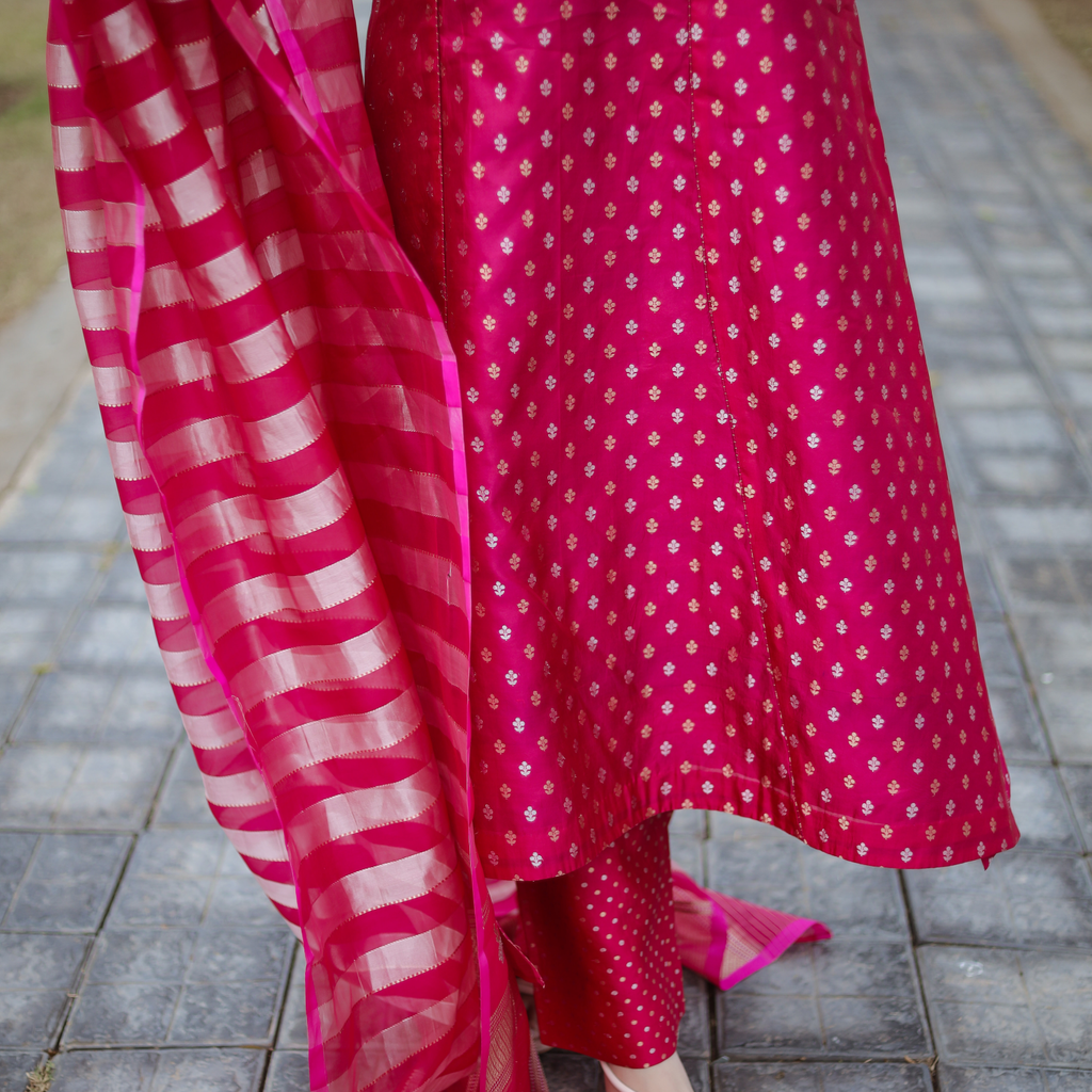 Close-up view of the pink Banarasi silk suit showing the matching zari dot patterned pants and the gold striped texture of the organza tissue dupatta