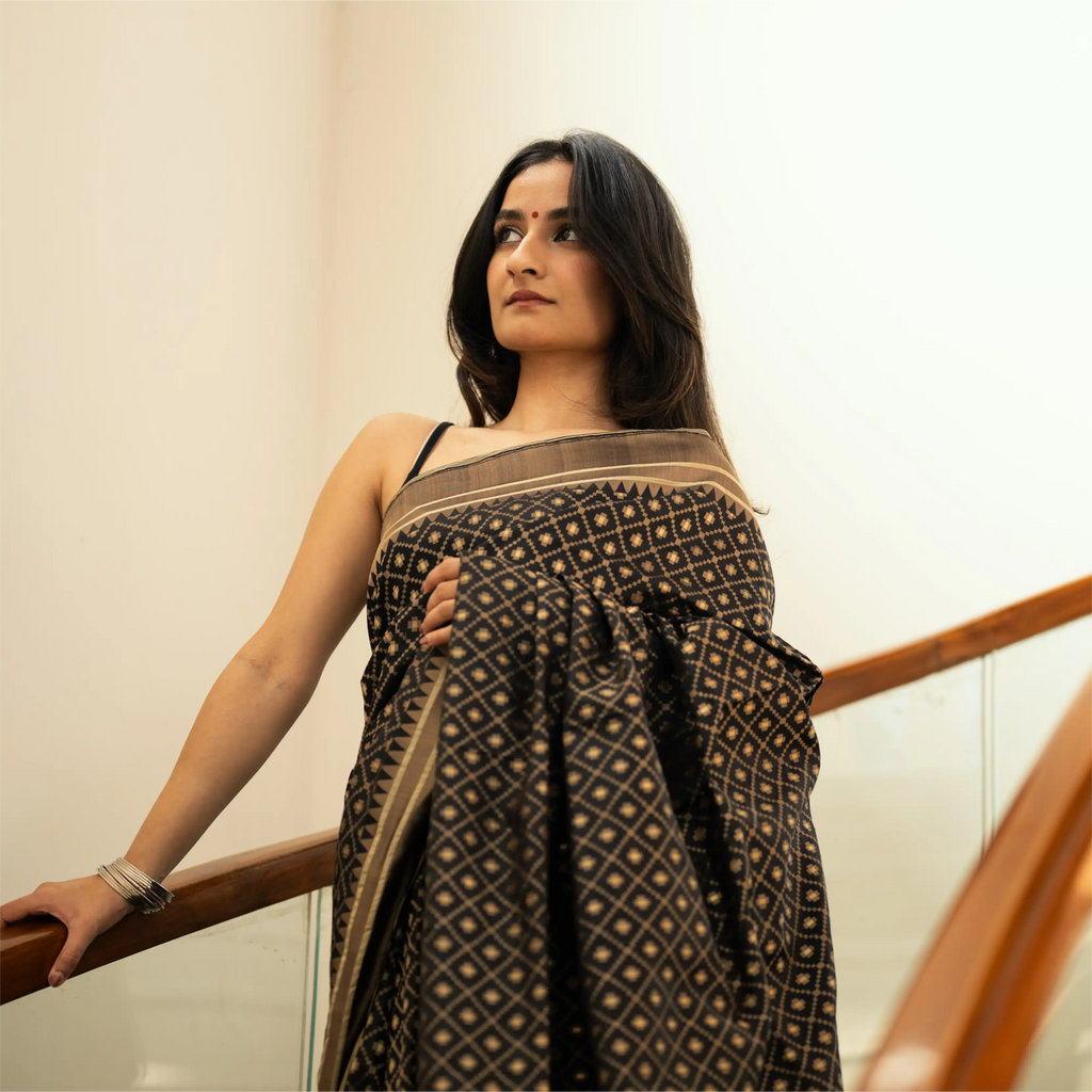 Side view of a Black Handwoven Katan Silk Saree showing the elegant drape and detailed gold zari geometric patterns.