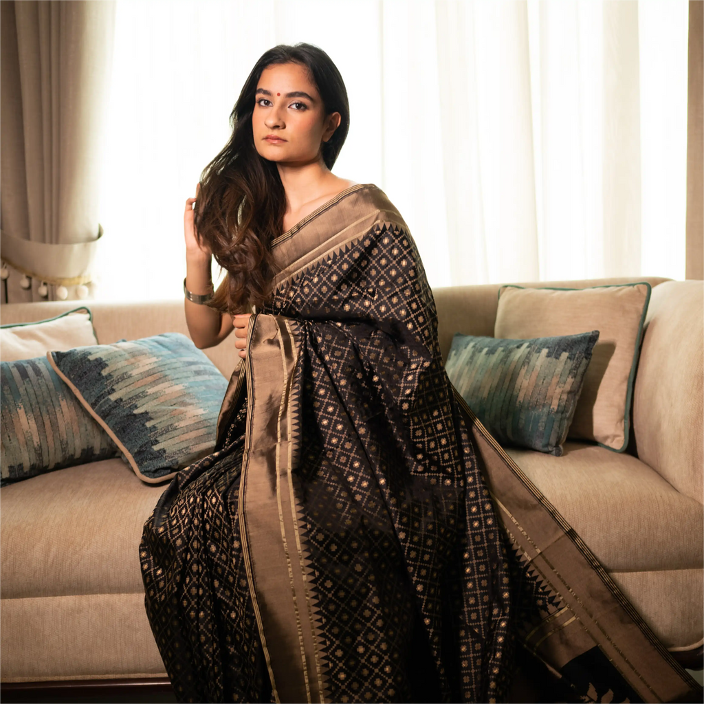 Luxurious drape of a Black Handwoven Katan Silk Saree on a model, highlighting the rich antique gold zari border and traditional Banarasi weaving.