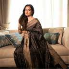 Luxurious drape of a Black Handwoven Katan Silk Saree on a model, highlighting the rich antique gold zari border and traditional Banarasi weaving.