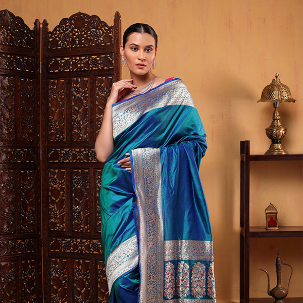 Detailed view of the vibrant Meenakari four-sided gold zari border on the handwoven blue azure katan silk saree.