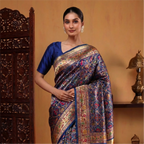 Woman wearing a Royal Blue Handwoven Paithani Patola Silk Saree with intricate geometric patterns, a gold zari border, and a matching silk blouse.