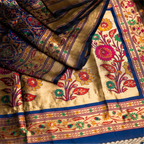Close-up of the royal blue Paithani Patola silk saree pallu featuring handwoven colorful parrot motifs and an intricate gold zari floral border.
