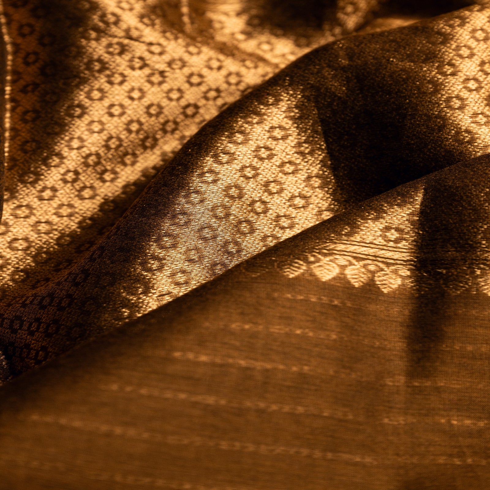 Detailed view of the traditional gold zari border and floral buta patterns on a brown Alfi silk saree, showcasing the rich hand-loomed craftsmanship.