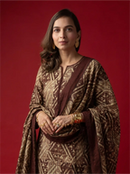 Woman wearing a brown and cream geometric-print traditional cotton kurta set with a matching dupatta against a solid red background