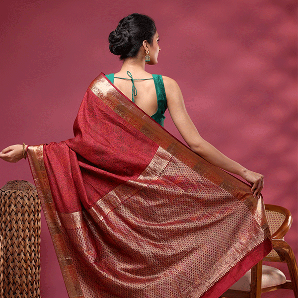 Detailed view of the elegant crimson silk saree pallu featuring a heavy and opulent traditional gold handwoven layout.
