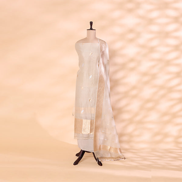 A mannequin displaying a serene cloud-grey handwoven organza silk suit, featuring delicate gold and silver zari work and an elegant matching dupatta.