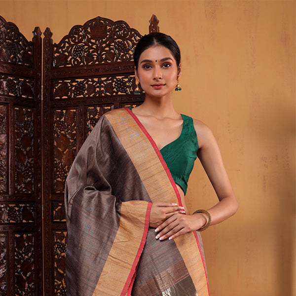 Model wearing the Coffee Elegance Handwoven Silk Saree in a rich coffee brown shade with a heavy border, paired with a green blouse.