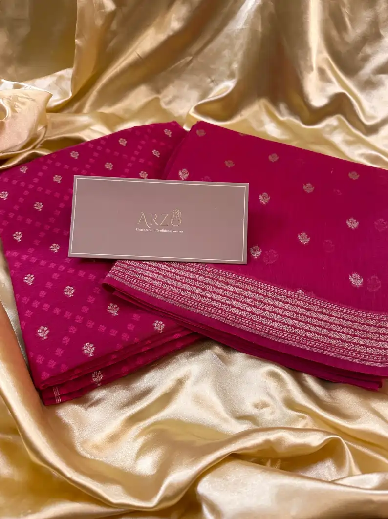 Close-up view of the fine ethnic craftsmanship and detailed woven border on the premium red Cotton Alfi unstitched suit fabric.