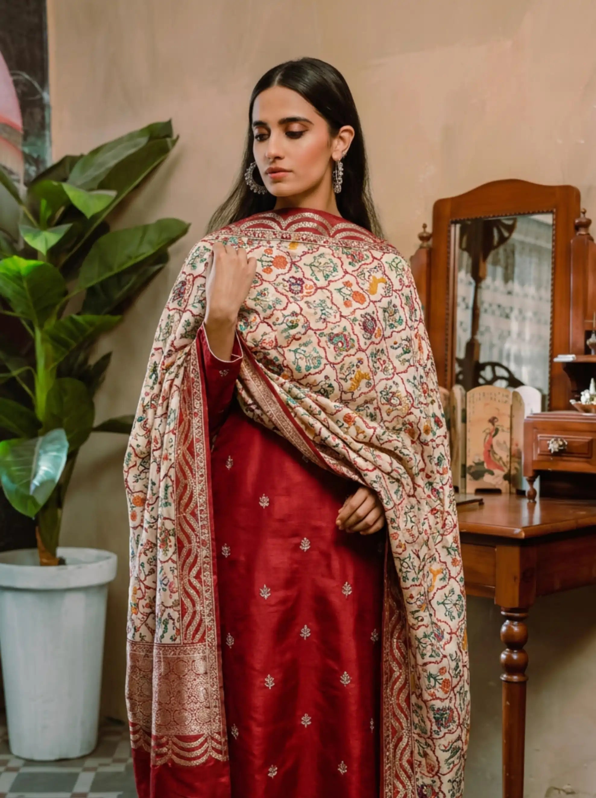 A woman wearing a premium crimson handwoven Banarasi silk suit paired with a traditional digital Kalamkari print dupatta.