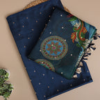 A flat-lay view of luxurious deep blue silk fabric, showcasing an intricate circular mandala design, vibrant peacock motifs, and elegant gold zari detailing.