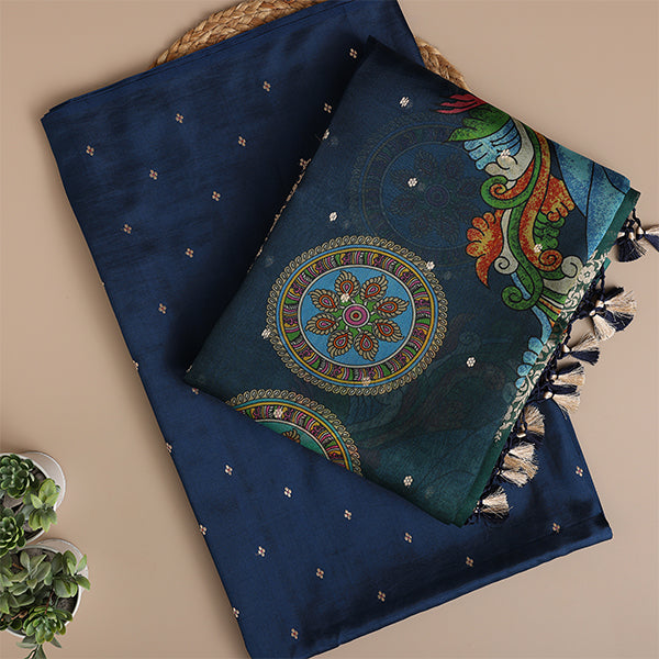 A flat-lay view of luxurious deep blue silk fabric, showcasing an intricate circular mandala design, vibrant peacock motifs, and elegant gold zari detailing.
