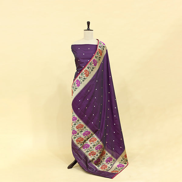 A mannequin displaying an elegant deep purple Banarasi silk suit, paired with a vibrant floral Kalamkari print dupatta featuring traditional intricate borders.