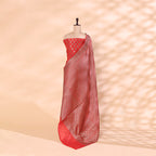 A mannequin showcasing an elegant red Banarasi silk saree, featuring intricate gold zari floral motifs and a traditional handwoven border, perfect for wedding and festive wear.