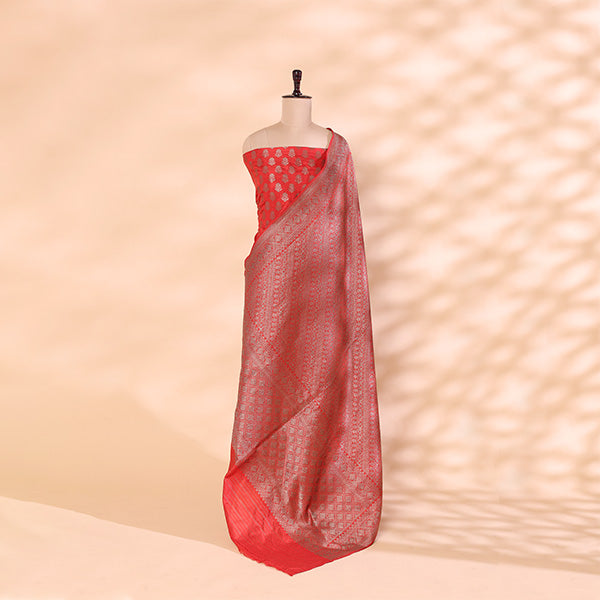 A mannequin showcasing an elegant red Banarasi silk saree, featuring intricate gold zari floral motifs and a traditional handwoven border, perfect for wedding and festive wear.