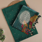 A flat-lay view of luxurious emerald green Banarasi silk fabric, showcasing an intricate handwoven circular mandala design, vibrant peacock motifs, and traditional gold zari detailing.