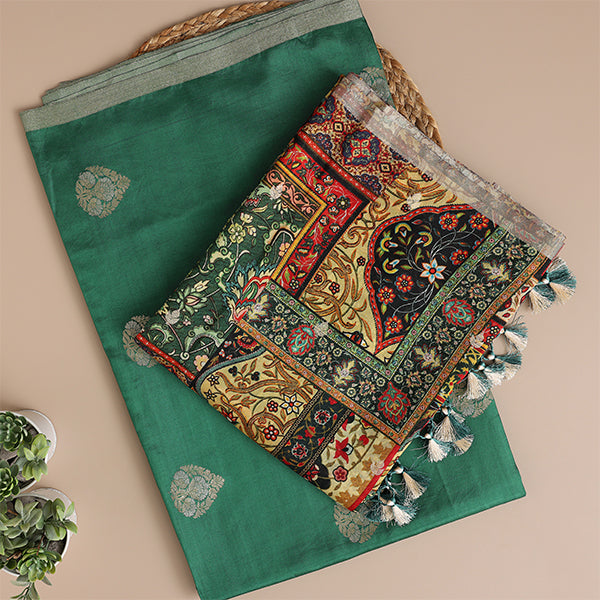 A beautiful flat-lay of an emerald green handwoven silk suit set, paired with a vibrant, multi-colored traditional dupatta featuring intricate woven patterns.