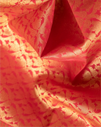A full-length view of the emerald green and orange Kanjivaram silk saree, highlighting its traditional border.