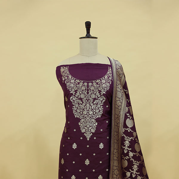 Detailed view of the luxury maroon Banarasi silk suit fabric highlighting the traditional hand-woven neck pattern and golden borders.