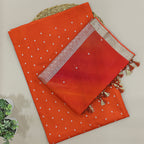 Close-up detail of the premium handwoven tie and dye silk fabric texture with shiny golden work on the body and border.