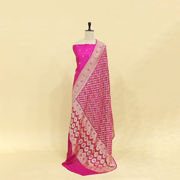 Detailed view of the fiery sunset red and gold Bandhani dupatta, showcasing traditional Indian tie-dye art and rich Zari border detailing.