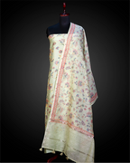 A mannequin displaying an elegant, light-colored Chanderi silk suit set featuring delicate floral patterns, intricate embroidery, and a matching dupatta, perfect for festive occasions.