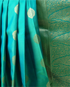 A full-length view showcasing the graceful drape and regal silhouette of the dark teal Kanjivaram saree.
