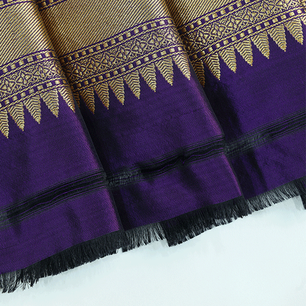 Macro shot of the premium pure katan silk fabric weave and gold zari borders of the Fuchsia Fantasy luxury wedding saree.