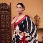 A woman wearing a light ivory handwoven Munga cotton silk saree with geometric black and off-white stripes, featuring a striking contrast fuschia border.