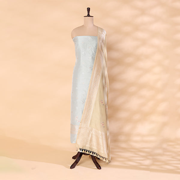 Unstitched handwoven pure Katan silk suit material in gleaming sky blue with a lustrous silver border, styled on a mannequin with a golden sunlit dupatta.