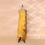 Unstitched golden yellow handwoven Banarasi silk suit set displayed on a mannequin, styled with a vibrant, multicolored traditional Kalamkari organza dupatta.