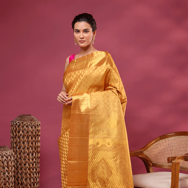 Detailed view of the luxurious heavy pallu featuring traditional handwoven patterns on the golden mustard Kanjivaram silk saree.