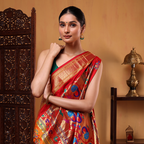 Side profile of a woman modeling the rich mustard yellow and red Paithani silk saree next to an ornate dark wooden screen partition.