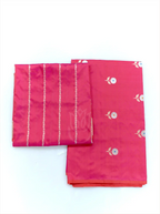 Folded magenta pink handwoven Banarasi silk suit fabric featuring silver floral bootis next to a matching tissue zari striped dupatta against a clean white background.