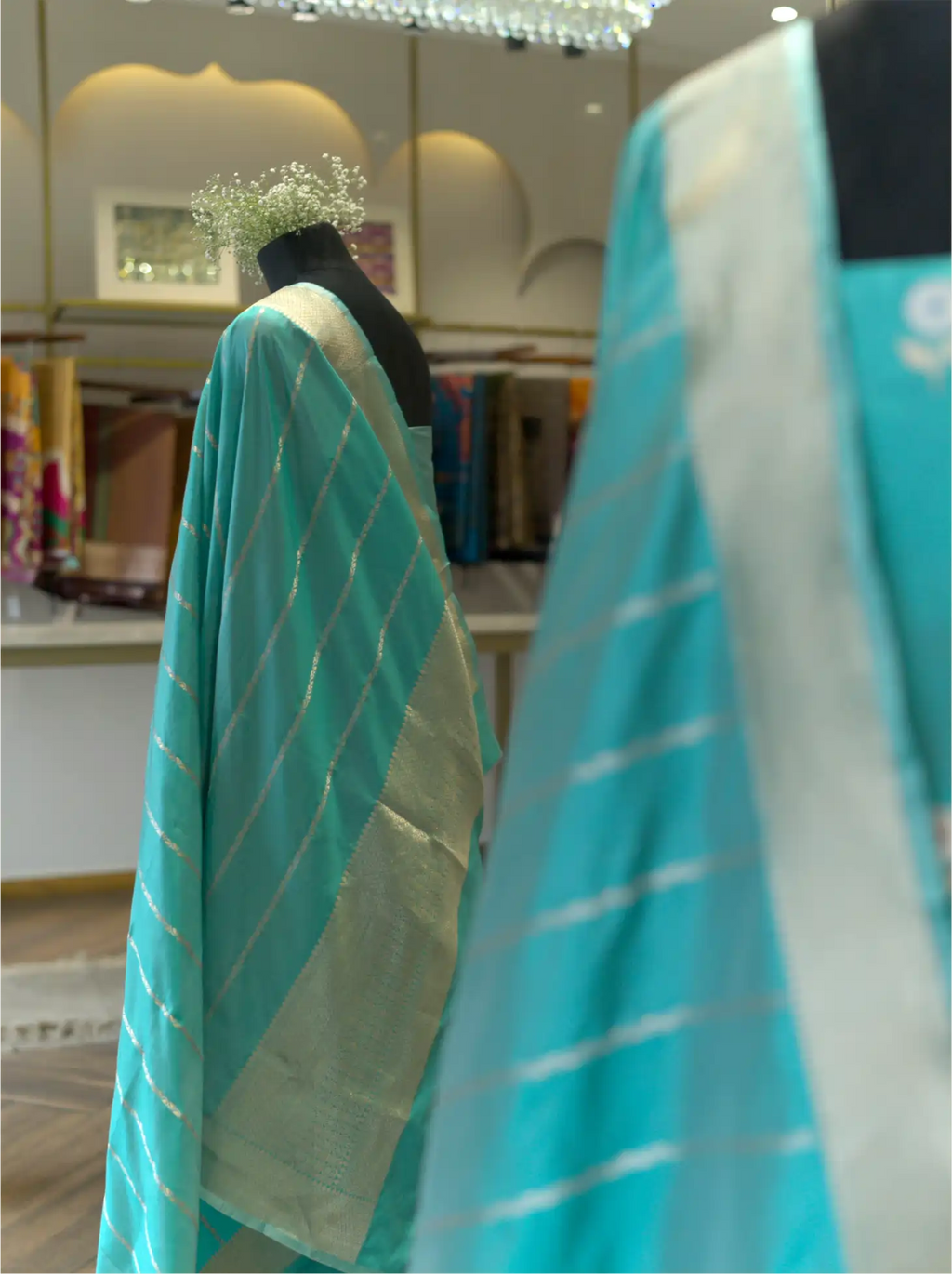 Sea green handwoven Banarasi silk dupatta with gold zari horizontal stripes draped on a mannequin in a boutique store setting
