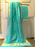 Macro close-up view of sea green handwoven Banarasi silk suit fabric highlighting the intricate weave, subtle sheen, and fine zari thread details