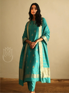 Model wearing Handwoven Banarasi Silk Suit Set in Sea Green featuring floral booti embroidery, matching trousers, and gold zari tissue dupatta