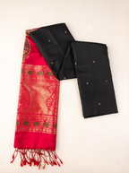Handwoven pure Paithani silk saree neatly folded to showcase its jet black body with gold zari buttis, juxtaposed against a rich crimson red pallu featuring traditional floral zari borders and finished with red tassels.