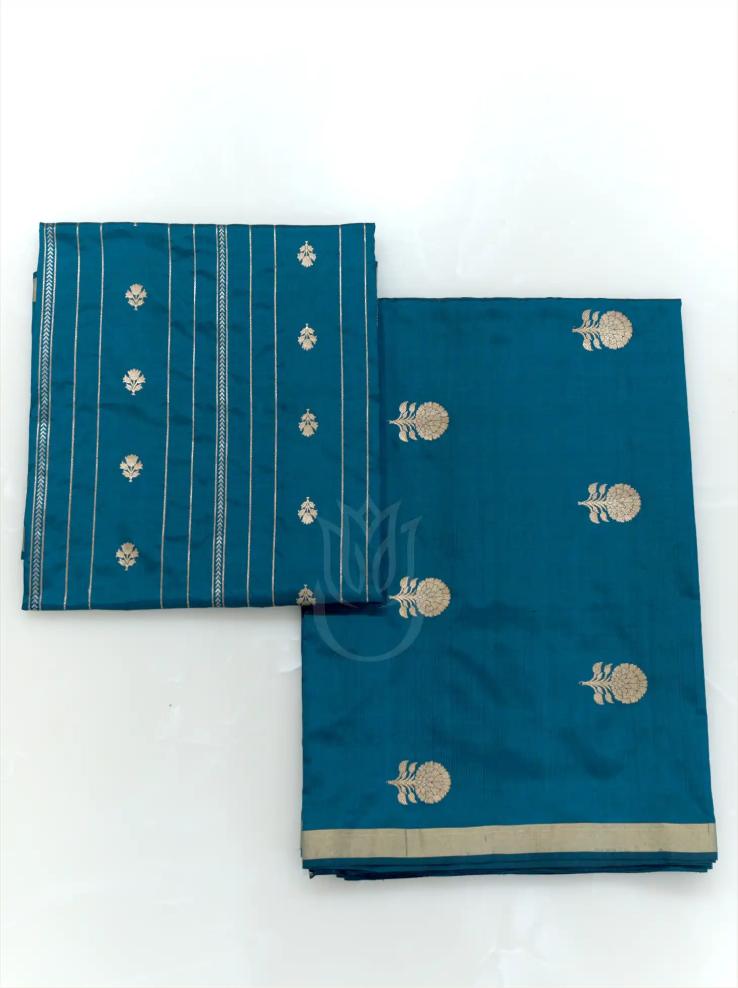 Folded teal blue handwoven Chinia silk suit fabric featuring gold zari floral bootis next to a matching striped zari dupatta against a clean white background.