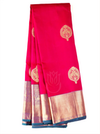 Handwoven crimson red pure Kanjivaram silk saree folded neatly against a white background, highlighting its gold zari motifs on the main body alongside a broad metallic gold and deep teal border.