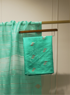 Seafoam green or emerald green handwoven silk suit fabric with gold and peach floral bootis folded on a wooden hanger, paired with a sheer gold-striped dupatta