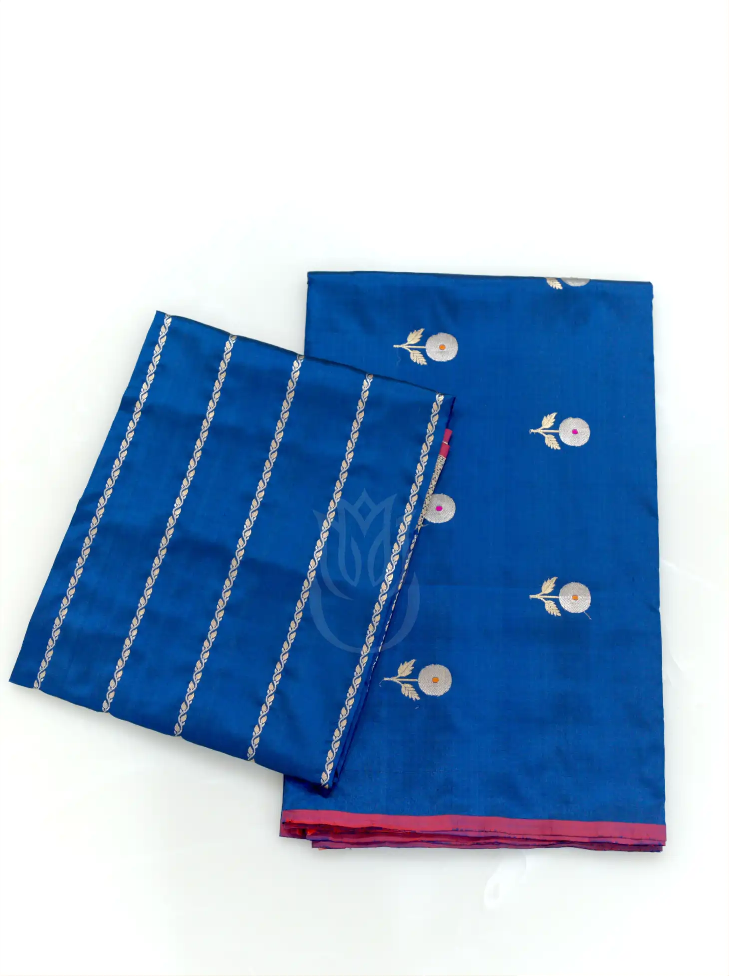 Folded royal blue handwoven Kora Katan silk suit fabric with silver floral bootis positioned beside a folded gold zari striped tissue dupatta against a plain white background.