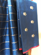 Folded royal blue handwoven Kora Katan silk suit fabric featuring silver floral bootis next to a matching gold zari striped dupatta with a contrast pink border.