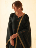 Woman modeling a charcoal black handwoven Matka silk kurta adorned with red meena bootis, styled with a draped dupatta featuring an antique gold tissue border
